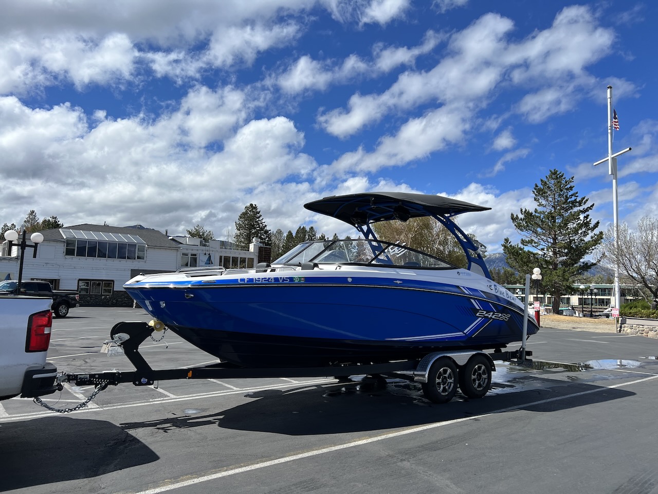 A boat on a boat trailer sitting in a parking lot.