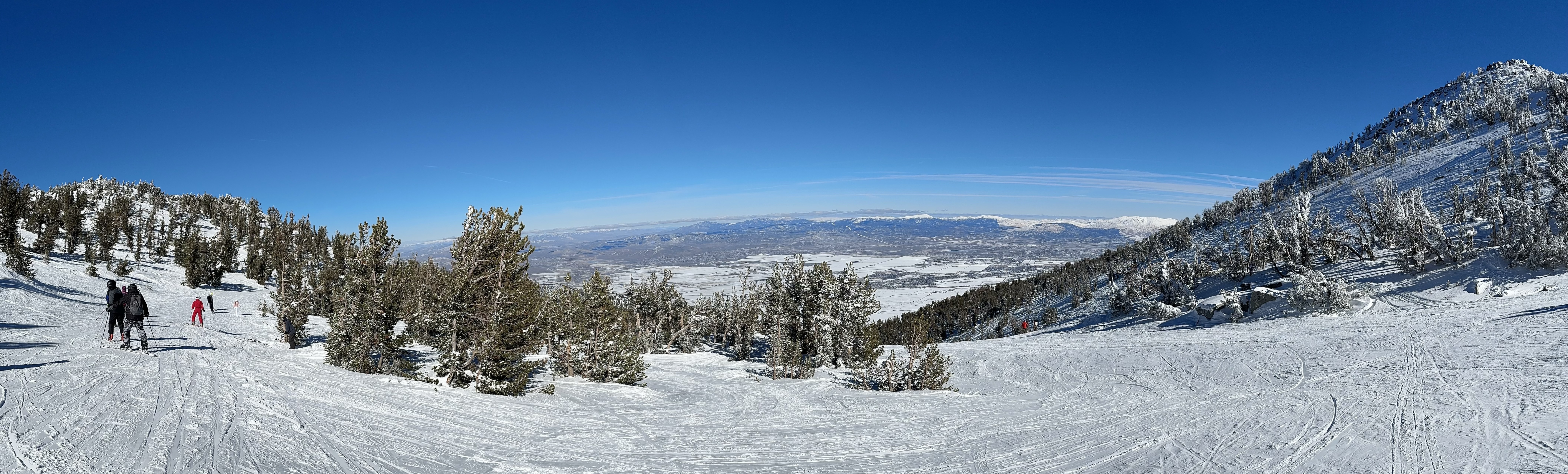 A ski trail going across the photo, distant square plots of farmland in the background.
