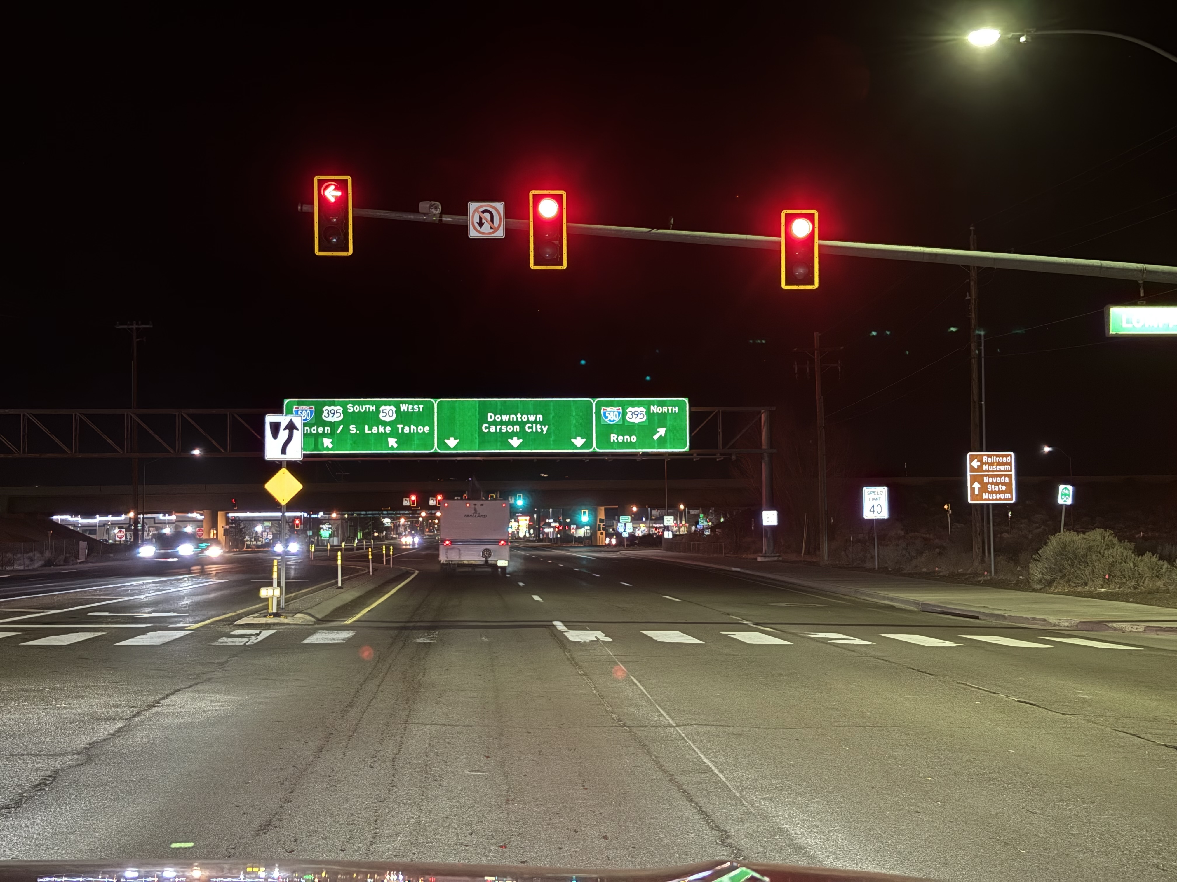 Street signs showing the on ramp to South Lake Tahoe, behind a red traffic light.