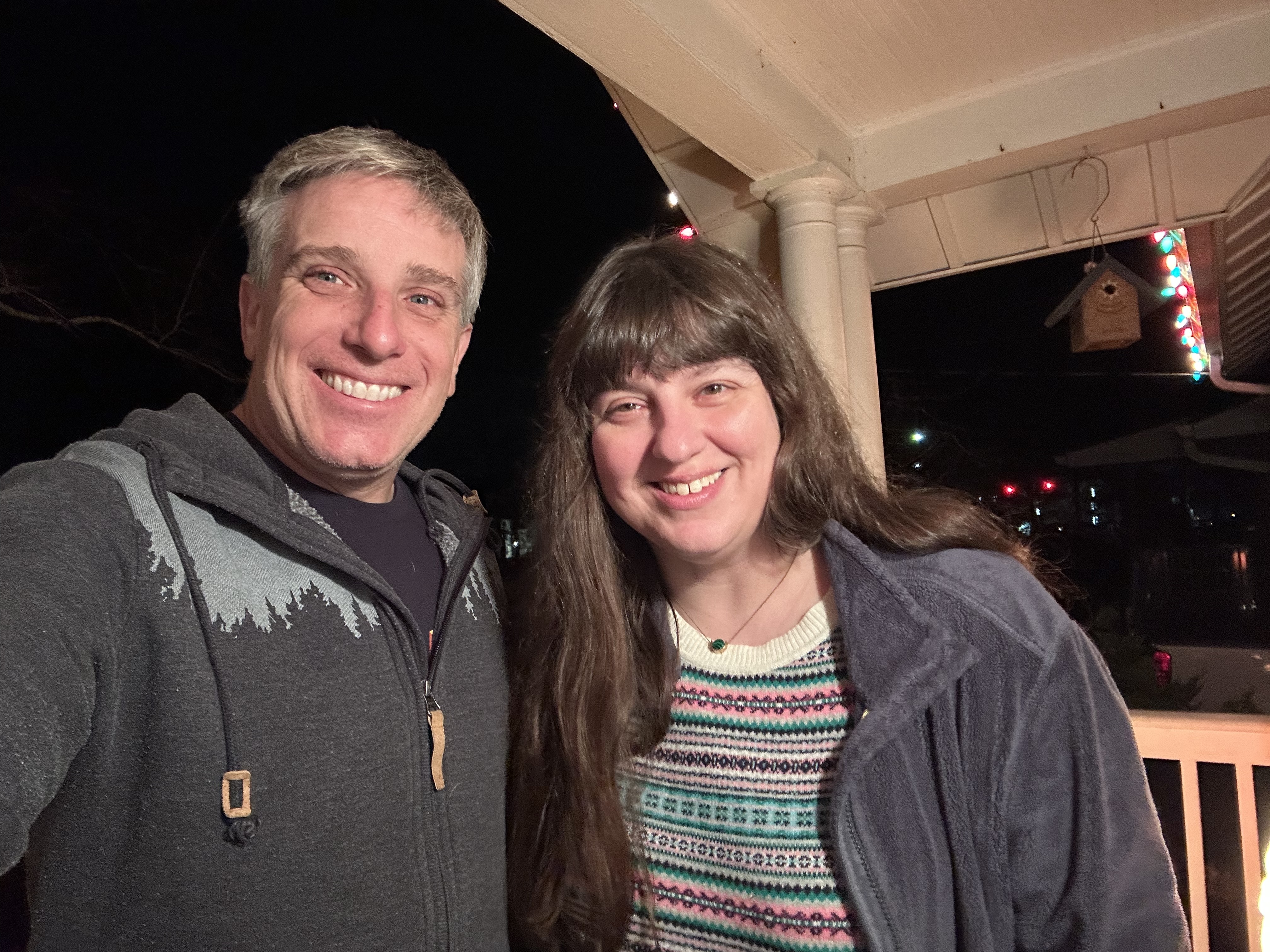 Two people standing on a porch.