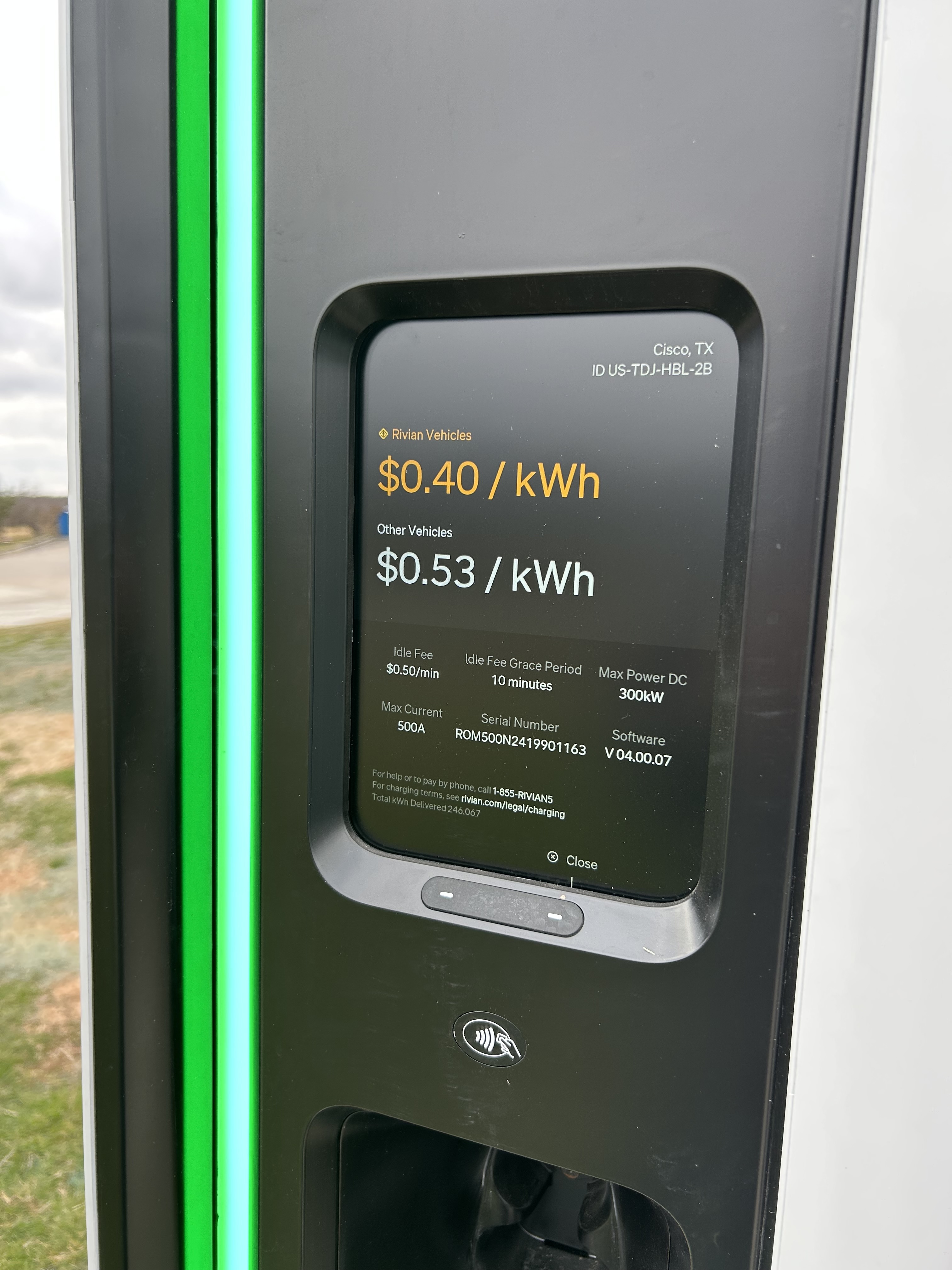 Screen of a charging station, showing a price of $0.40 per kWh for Rivian vehicles and $0.53 per kWh for other vehicles, along with other legal text and information.